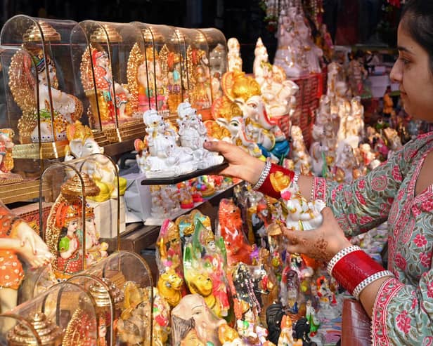  A woman holds the idols of Hindu deities ahead of the Hindu festival of Diwali at a market in Amritsar on October 19, 2022. (Photo by Narinder NANU / AFP) (Photo by NARINDER NANU/AFP via Getty Images)