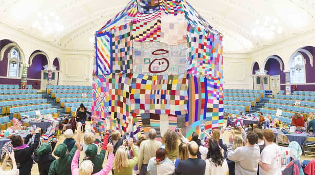 People watch as workers place a giant bobble on top of a 23 foot high bobble hat in celebration of the 20th anniversary of the innocent Big Knit in partnership with Age UK (photo: Dominic Lipinski/PA Wire)