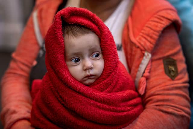 A Ukrainian woman holds her 3-month-old baby at the Western Railway Station as they flee Ukraine on March 9, 2022 in Budapest, Hungary. 