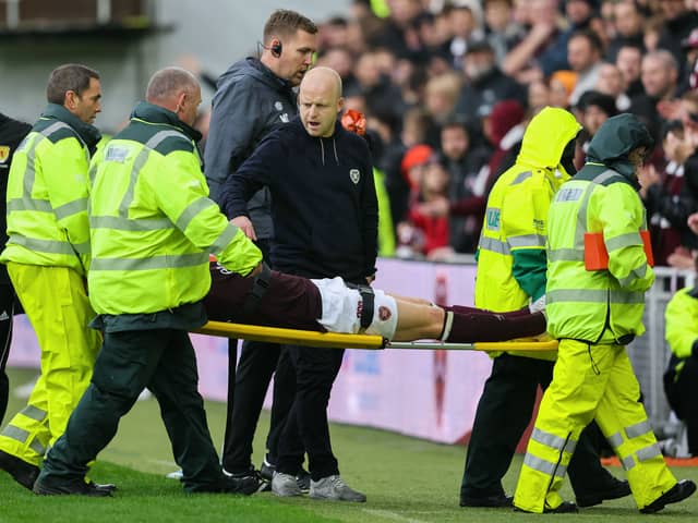 Hearts head coach Steven Naismith consoles Stephen Kingsley as he is stretchered off. Pic: SNS