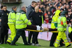 Hearts head coach Steven Naismith consoles Stephen Kingsley as he is stretchered off. Pic: SNS