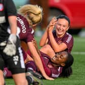 Hearts players pile on Sade Adamolekun after she netted a 95th-minute winner. Credit: Malcolm Mackenzie