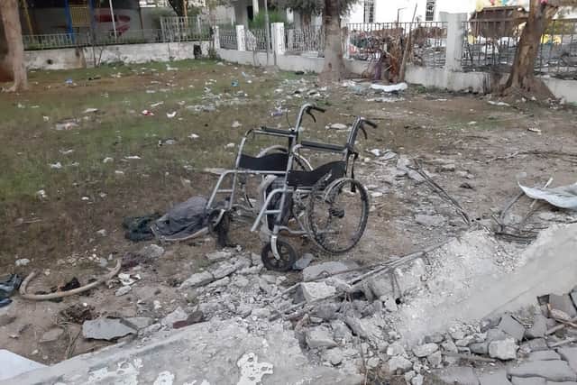 A mangled wheelchair sits among debris