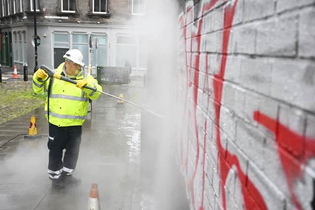 A council worker removing graffiti from a wall - the service could be expanded following the summit.