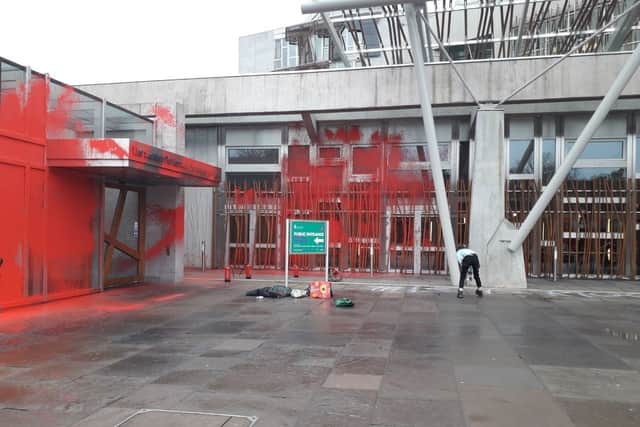 Three activists from This is Rigged sprayed The Scottish Parliament red in a protest over food insecurity. 