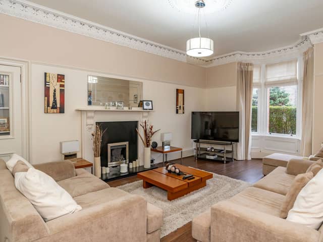 The bright and spacious sitting room with bay window, gas fire with an attractive surround, decorative cornicing and ceiling rose and a shelve display press.