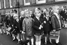 Girls wait in the playground on their first day at Flora Stevenson primary school in Edinburgh in August 1970. Rosemary Holden, in front, has a rose for her new teacher.