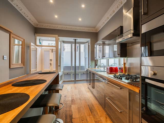 On the ground level, there is a modern kitchen with grey gloss units, mirrored splashback, integrated appliances and a breakfast bar that can seat up to four people for casual dining. The room has great character and features intricate cornicing and hardwood flooring which also runs throughout much of the property.