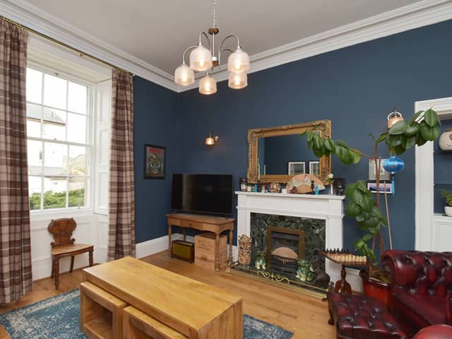 The spacious living room is well presented with a high ceiling and a fireplace. There is an arched entrance from here into the dining area.