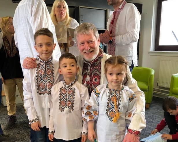 Dnipro Kids chairman Steven Carr with some of the kids in traditional Vyshyvanka shirts.