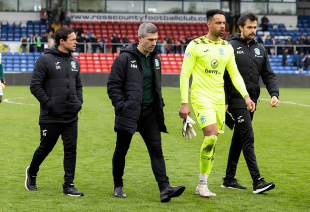 Goalkeeper Jojo Wollacott and the Hibs coaching staff leave the pitch at full-time in Dingwall. 
