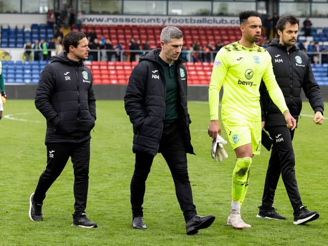 Goalkeeper Jojo Wollacott and the Hibs coaching staff leave the pitch at full-time in Dingwall. 
