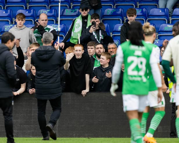 Hibs staff and players engage with travelling fans after the weekend collapse in Dingwall.