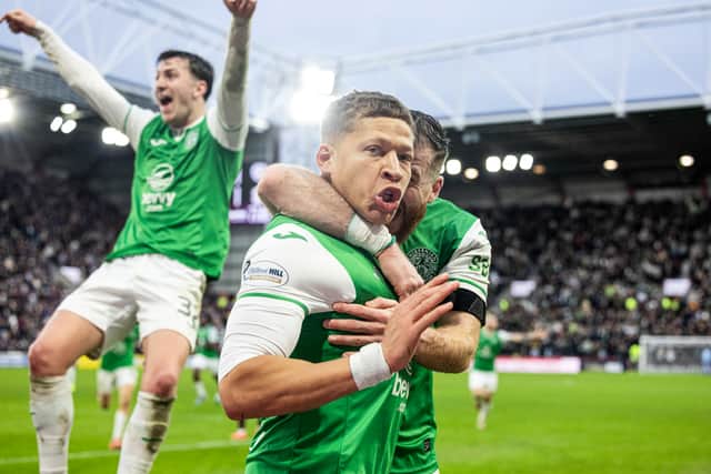 Dwight Gayle is embraced by Nicky Cadden as Josh Campbell leaps for joy; Gayle has just scored the winner at Tynecastle.