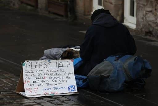 Stock photo of a homeless person and their dog on the Royal Mile in Edinburgh.