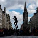 Tourists on the Royal Mile watching a Fringe performer.