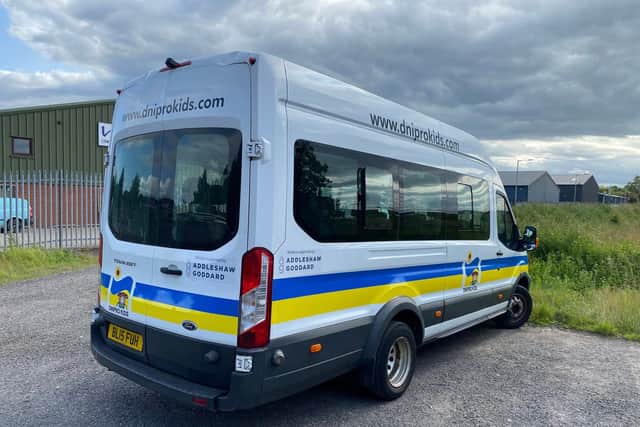 The mini bus prominently displays the charity's branding.