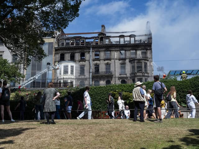 Crowds of onlookers watch on as firefighters deal with the aftermath of the blaze.