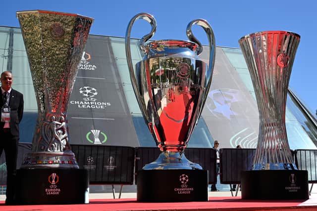 Giants cups representing (from L) the UEFA Europa League trophy, the UEFA Champions League Trophy and the UEFA Conference League trophy are displayed outside the Grimaldi forum in Monaco where the draw takes place this week.