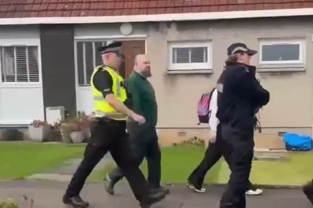 Calum MacFadyen being escorted from his home by police officers on Saturday afternoon.
