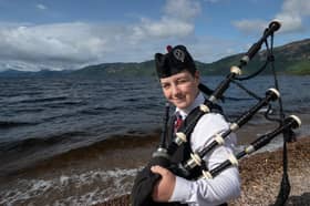 Elliot with his bagpipes at Loch Ness after winning first place at a bagpiping competition at Drumnadrochit Highland Games 