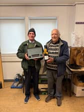 Owner Brian Irvine receiving his prize for the 1000th repair from repairer Angus Maclennan
