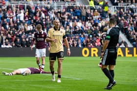 St Mirren's Alex Gogic (C) is shown a yellow card by Referee Nick Walsh as he fouls Hearts' Josh McPake inside the box conceding a penalty 