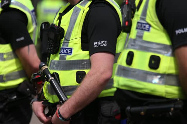 A row of Police Scotland officers in high-vis jackets