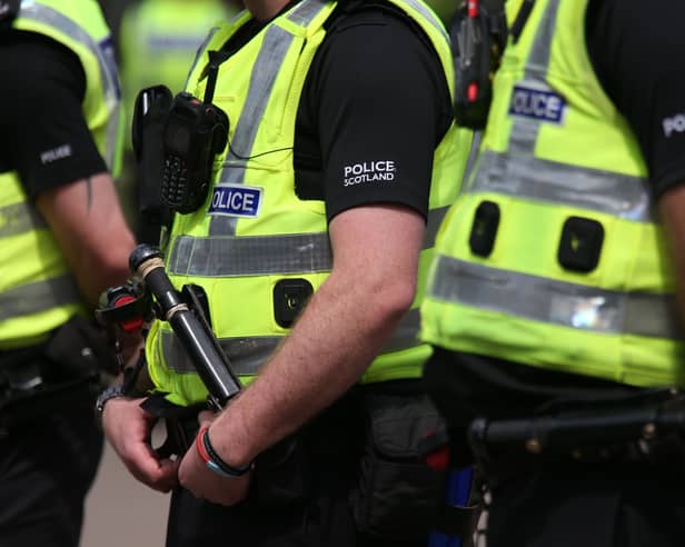 A row of Police Scotland officers in high-vis jackets