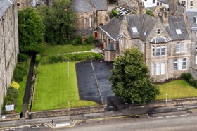 The office building on the right would house the four flats, while the adjacent vacant land would become a car park and four separate gardens.