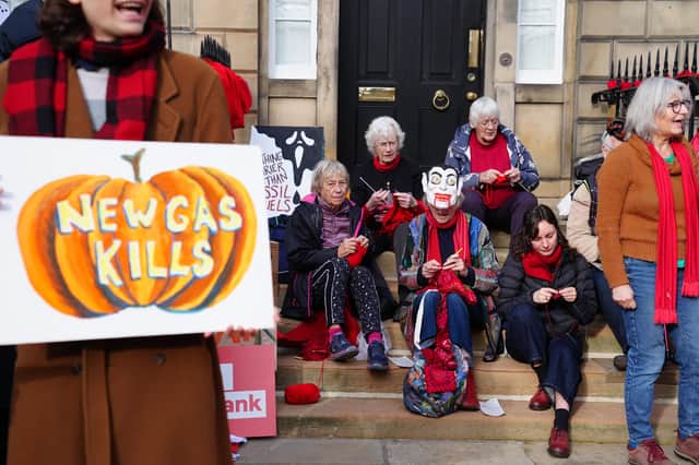 Protesters held placards with messages such as “fossil fuel ghouls” and “this decision will haunt you”