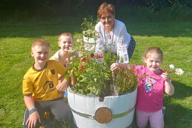 Haleh Nather, chair of Livingston Village Community Garden and children who have helped plant