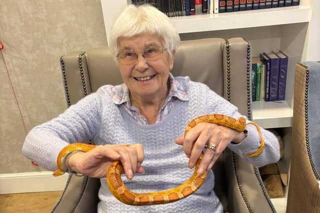 Cairdean House resident, Dorothy Low, holding a snake