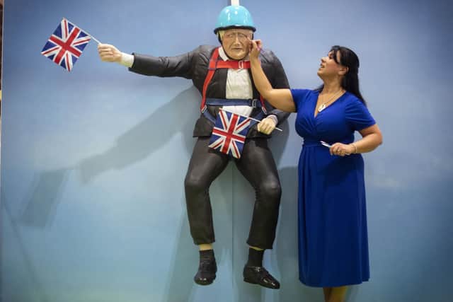 Having his cake and eating it? Rosie Dummer puts the final touches to a life-sized Boris Johnson cake at the Cake and Bake Show in London. (Picture: Victoria Jones/PA Wire)