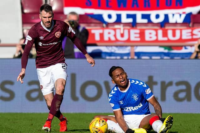 Hearts' Michael Smith charges away as Alfredo Morelos sits on the turf. Picture: SNS