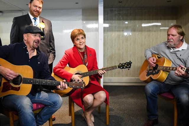 First Minister Nicola Sturgeon gestures as she holds a guitar during a campaign visit to Dalkeith Community Hub in Dalkeith. Picture: AFP/Getty Images/Andy Buchanan