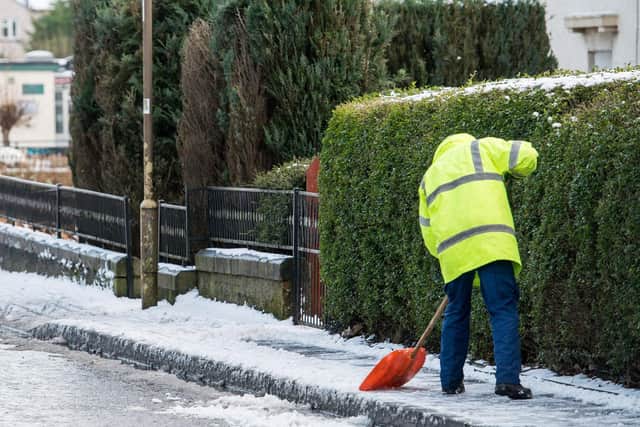 Snow being cleared from a pavement.