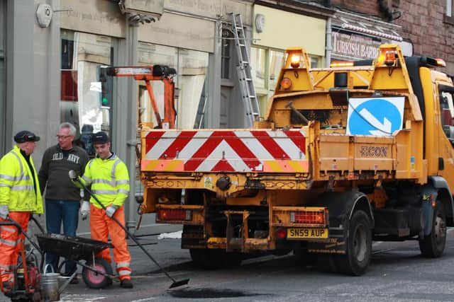 Workmen fill in a pothole on Causewayside after it damaged a car tyre.