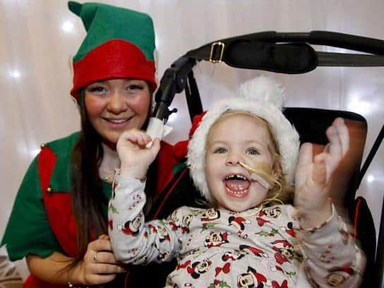 Elf Emily Glagow puts a smile on the face of four-year-old CC McCann.