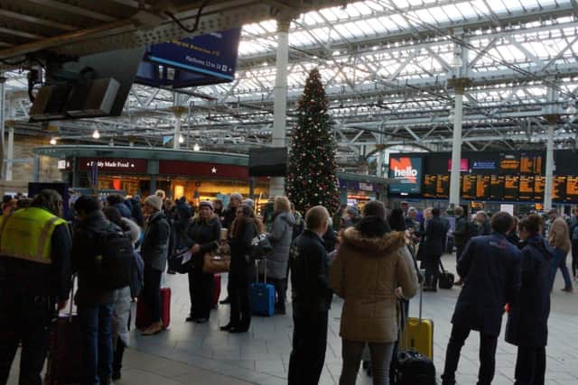 Passengers queue for the information desk at Edinburgh Waverley this afternoon
