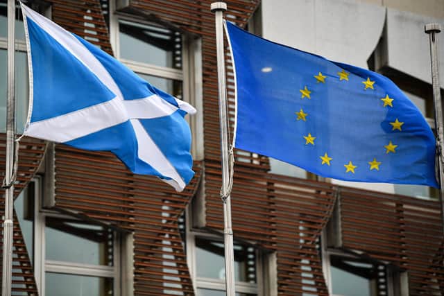 The Saltire and the EU flag fly side by side outside the Scottish Parliament (Picture: Getty)