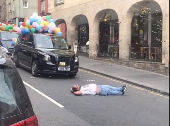 A private hire driver lay down in front of a taxi charity parade last summer