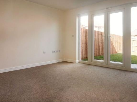 The lounge is neutrally decorated, carpet and a set of double patio doors that lead to the rear garden.