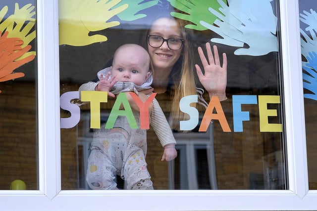 Scarborough residents placed Covid-19 messages in their windows; Neavie and Ella Bulman look out of their window.