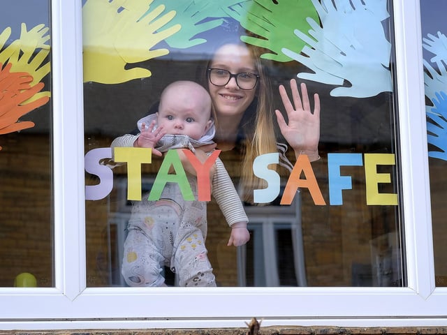 Scarborough residents placed Covid-19 messages in their windows; Neavie and Ella Bulman look out of their window.