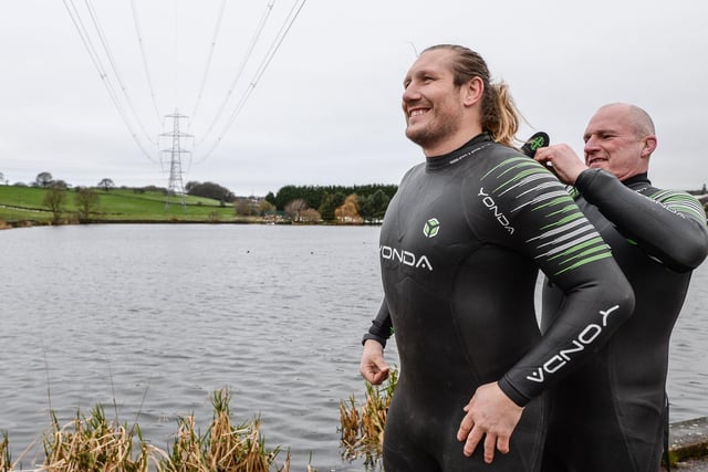 Former International Rugby League Player Eorl Crabtree is helped into his wetsuit by Andy Kelly as they prepare to swim through icy water in a New Year’s Day dip to raise awareness of MND and Rob Burrow.