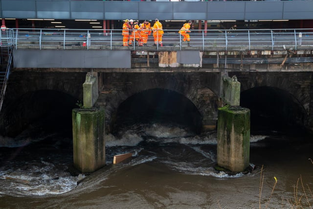 The River Aire at Leeds City Station as work men check for damage