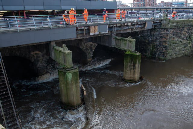 The River Aire at Leeds City Station as work men check for damage