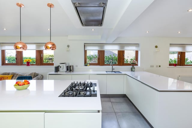 Integral appliances are hidden from view in this white kitchen with Corian work tops.