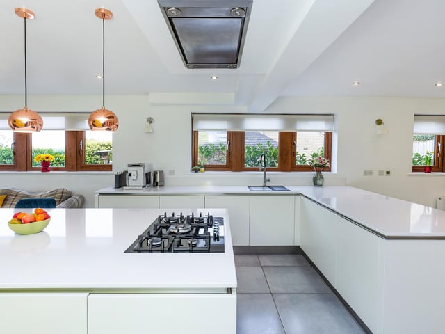 Integral appliances are hidden from view in this white kitchen with Corian work tops.